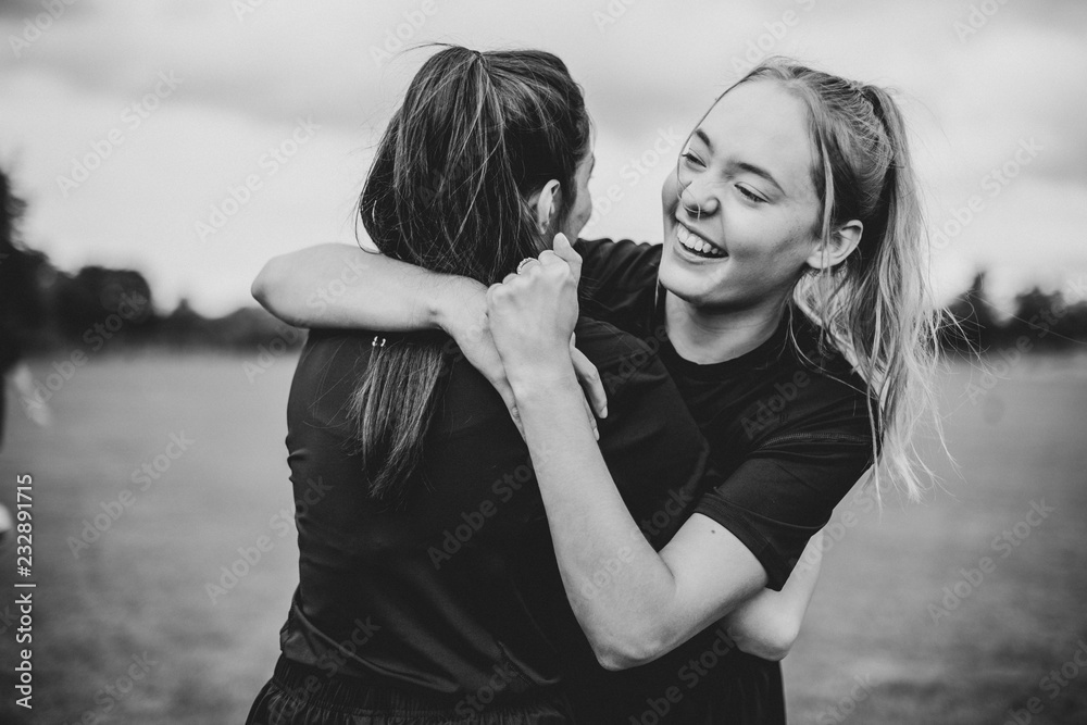 Female football players hugging each other