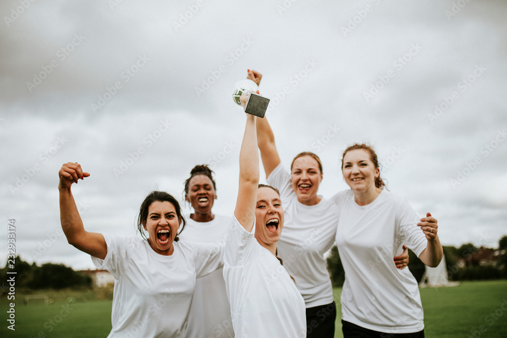 Cheerful female football players celebrating their victory