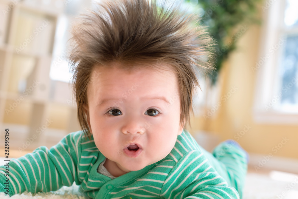 Happy newborn baby boy playing on the carpet