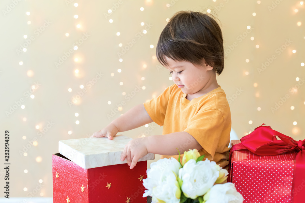 Happy toddler boy with Christmas present boxes