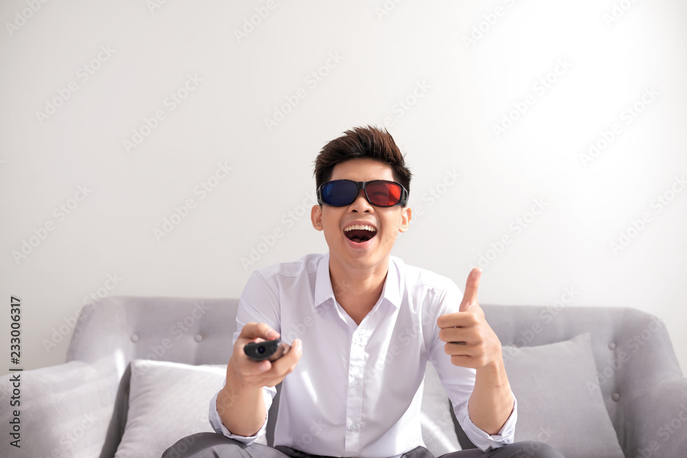 handsome man in 3d glasses sitting on sofa and watching tv