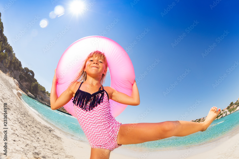 Happy girl dancing with rubber ring on the beach