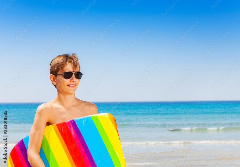 Happy young surfer preparing to ride the wave