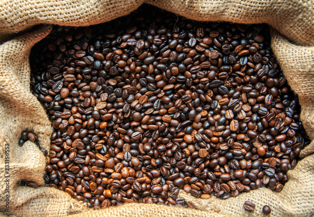 Roasted coffee beans. Coffee beans close-up, background. A warehouse of bags full of delicious, deli