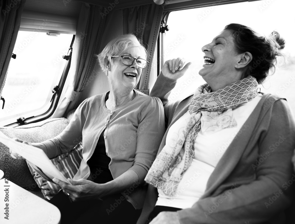 Cheerful elderly women discussing the newspaper