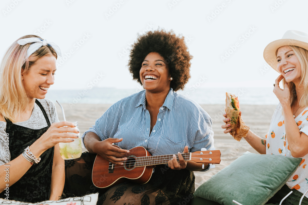 Friends singing together at a beach picnic