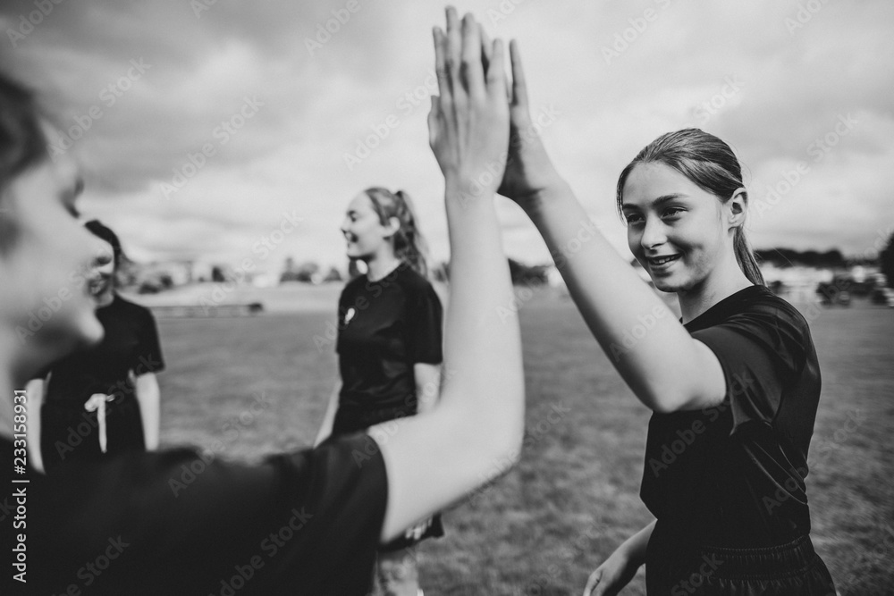 Female football players giving each other high five