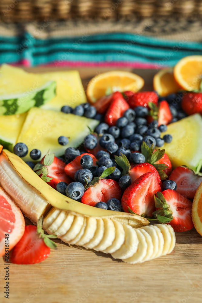 Fresh fruits on a wooden board at a picnic