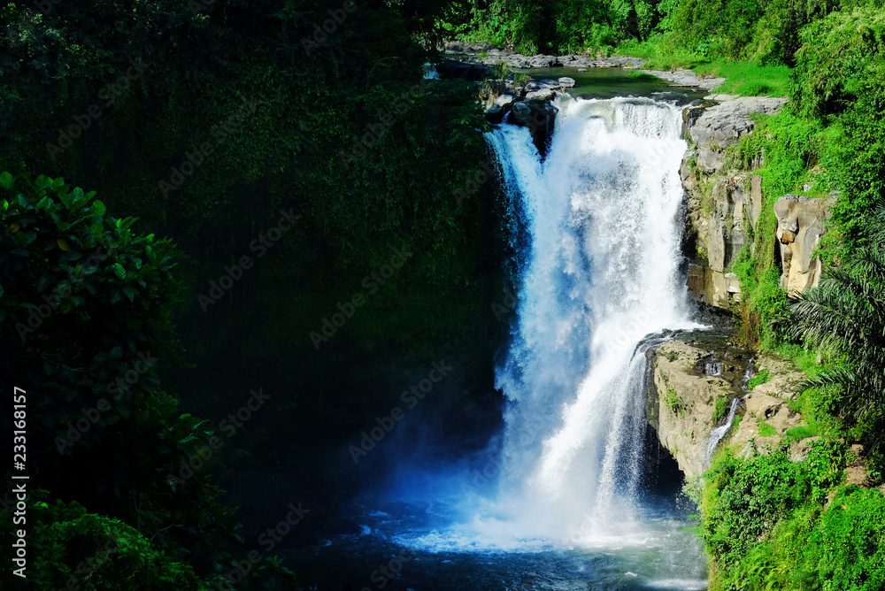 Jumping into the water. Man having fun at waterfalls in the nature. Bali, Indonesia