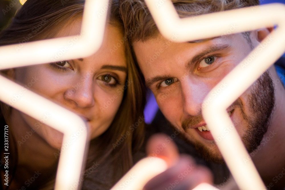 Couple in love at Christmas evening holding glowing white LED star