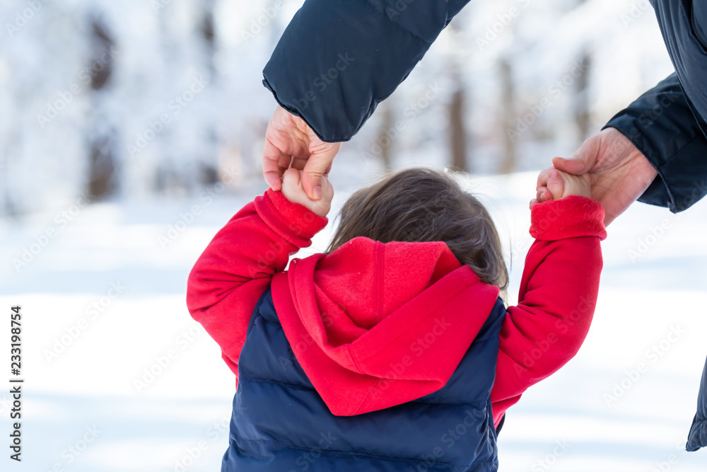 蹒跚学步的男孩和妈妈在雪地里玩耍