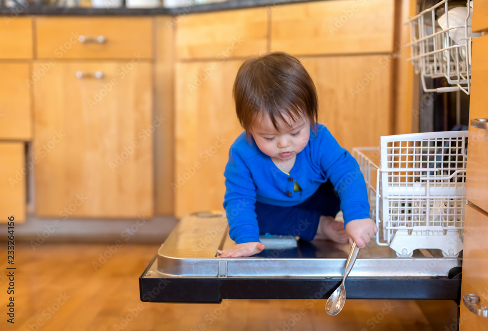 Toddler boy playing around in the kitchen