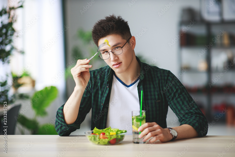 健康饮食。快乐的年轻人早上在厨房吃沙拉