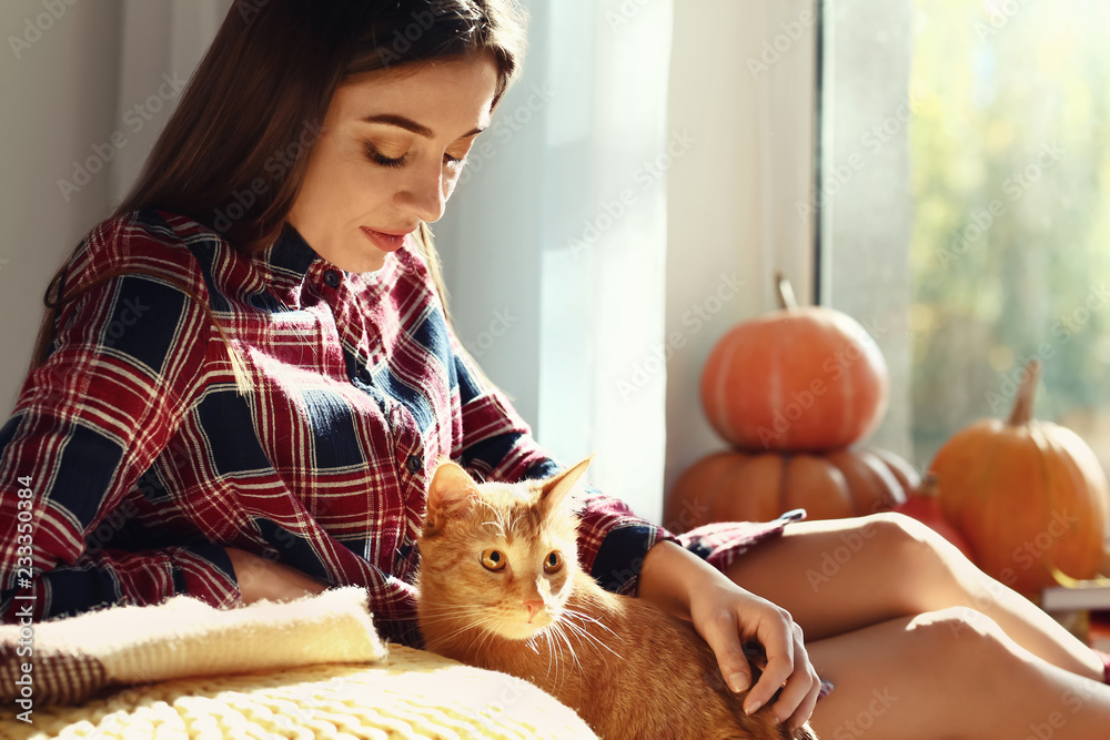 秋天的一天，带着可爱的猫在家休息的女人