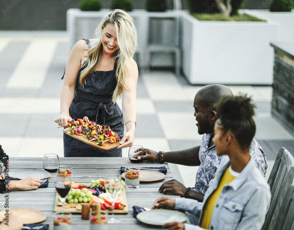 Woman serving vegan barbecue to her friends