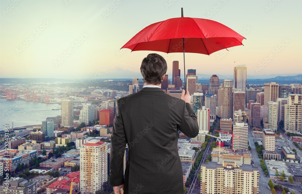 Portrait of  businessman with umbrella on background