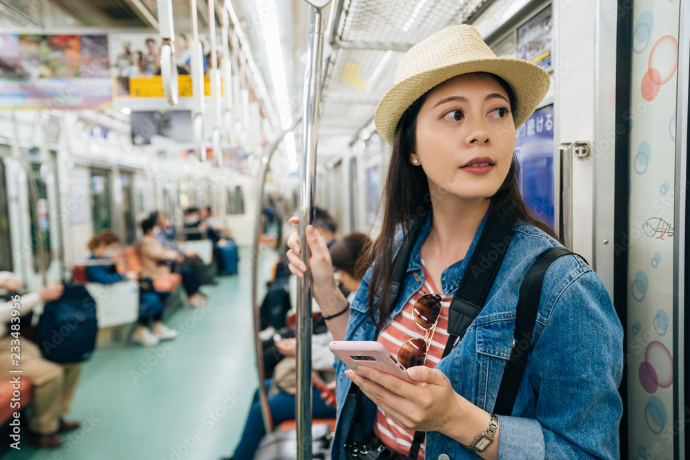 年轻旅行女性在火车内使用手机