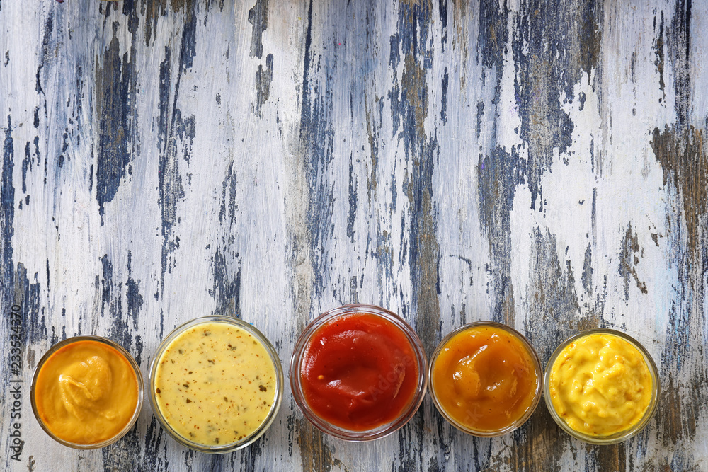 Different tasty sauces in bowls on wooden table