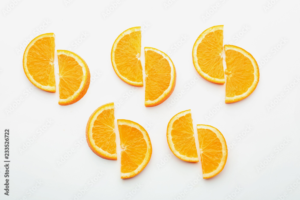 Slices of tasty ripe orange on white background