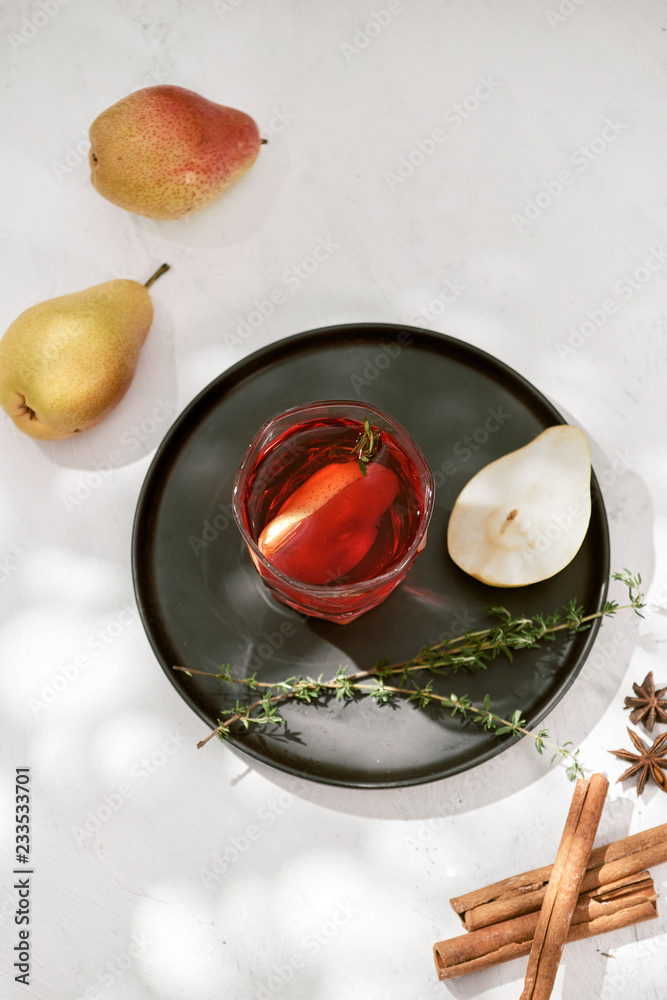 Delicious spicy hot mulled red wine with cinnamon, star anise and slice pear served in a carafe and 