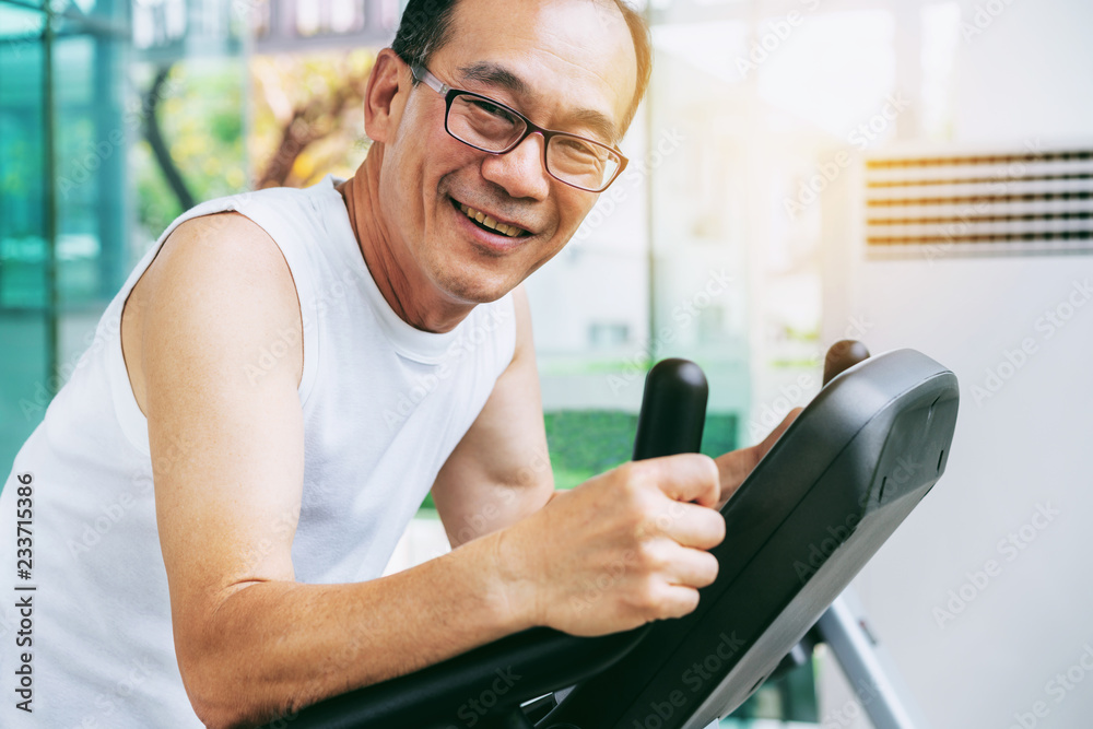 Senior man exercise on treadmill in fitness center. Mature healthy lifestyle.