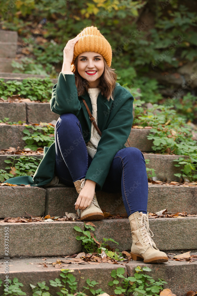 Beautiful young woman sitting on stairs outdoors