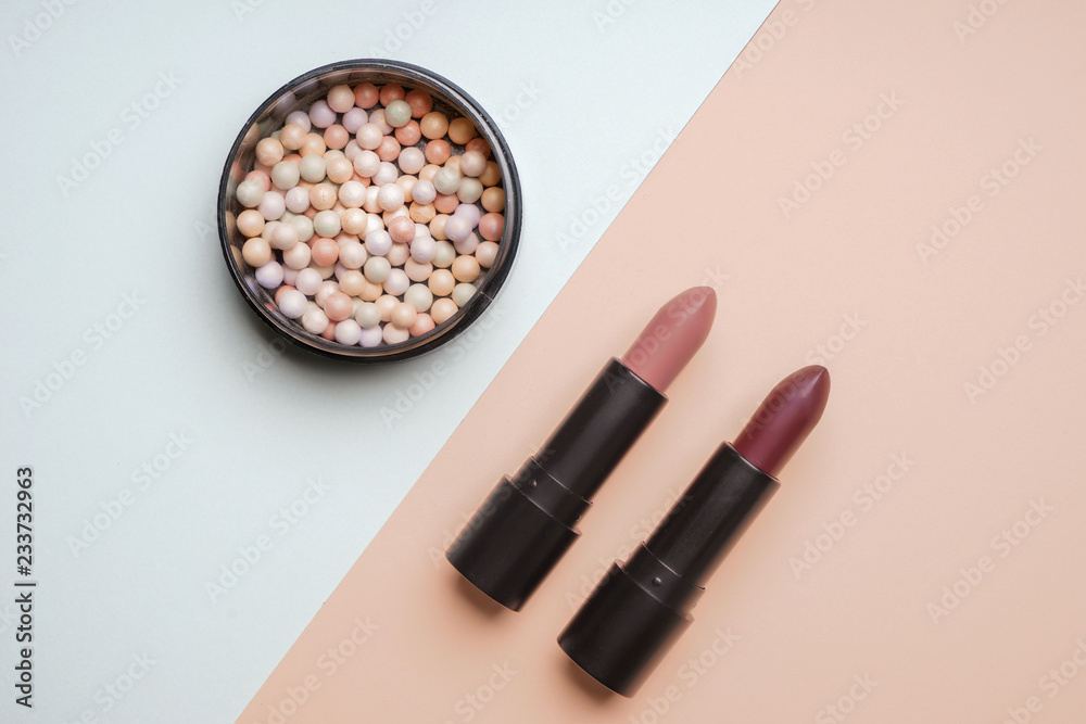 Lipsticks with face powder on color background