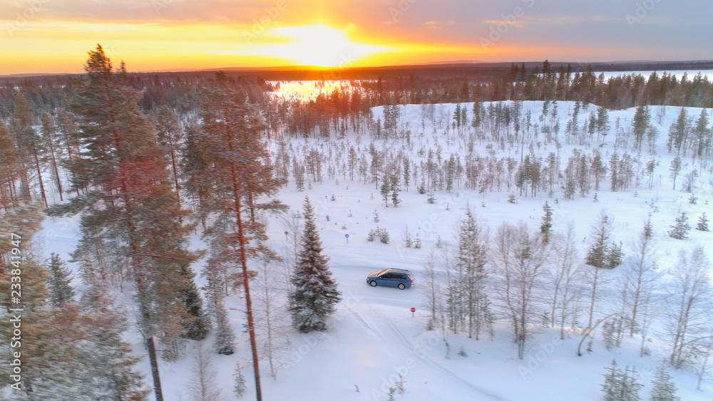 空中飞航：拉普兰金色日落时，汽车驶过白雪皑皑的冬季仙境