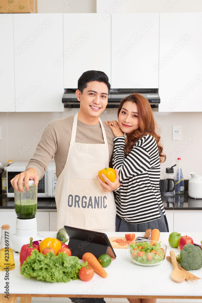 幸福的夫妻在厨房做饭。男人和女人在厨房做饭很开心。