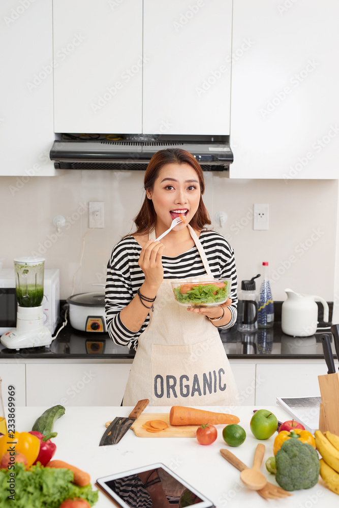 家里有健康的食物。快乐的女人正在厨房里准备蔬菜和水果。