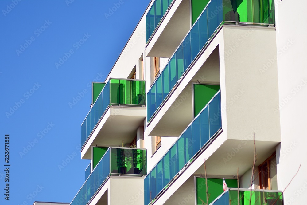 Fragment of a facade of a building with windows and balconies. Modern home with many flats.