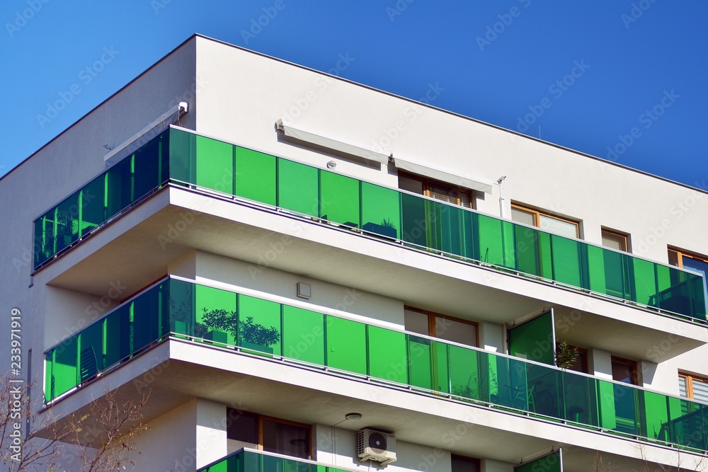 Fragment of a facade of a building with windows and balconies. Modern home with many flats.