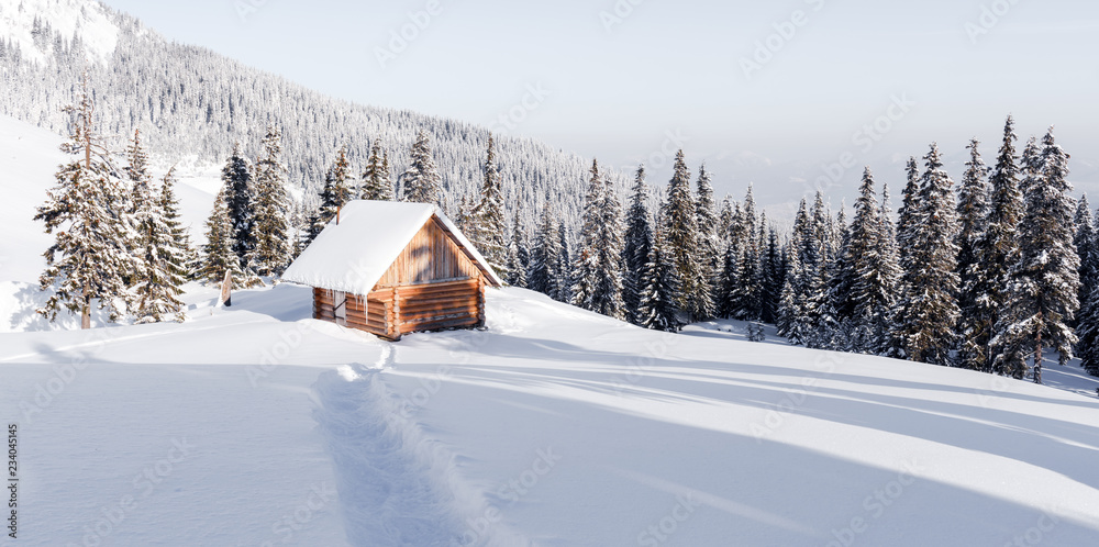 Fantastic winter landscape with wooden house in snowy mountains. Christmas holiday concept. Carpathi