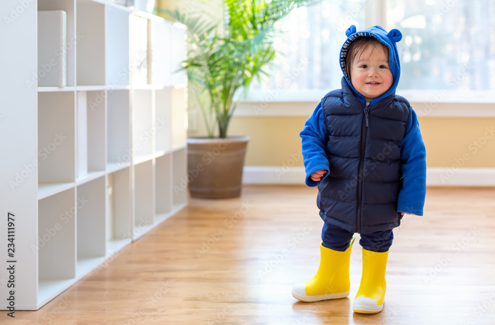 Toddler boy bundled up in winter clothes ready to go outside