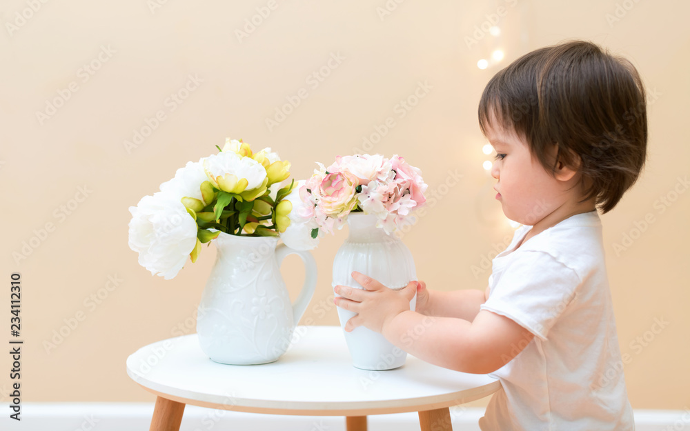 带着一束漂亮花的蹒跚学步的男孩