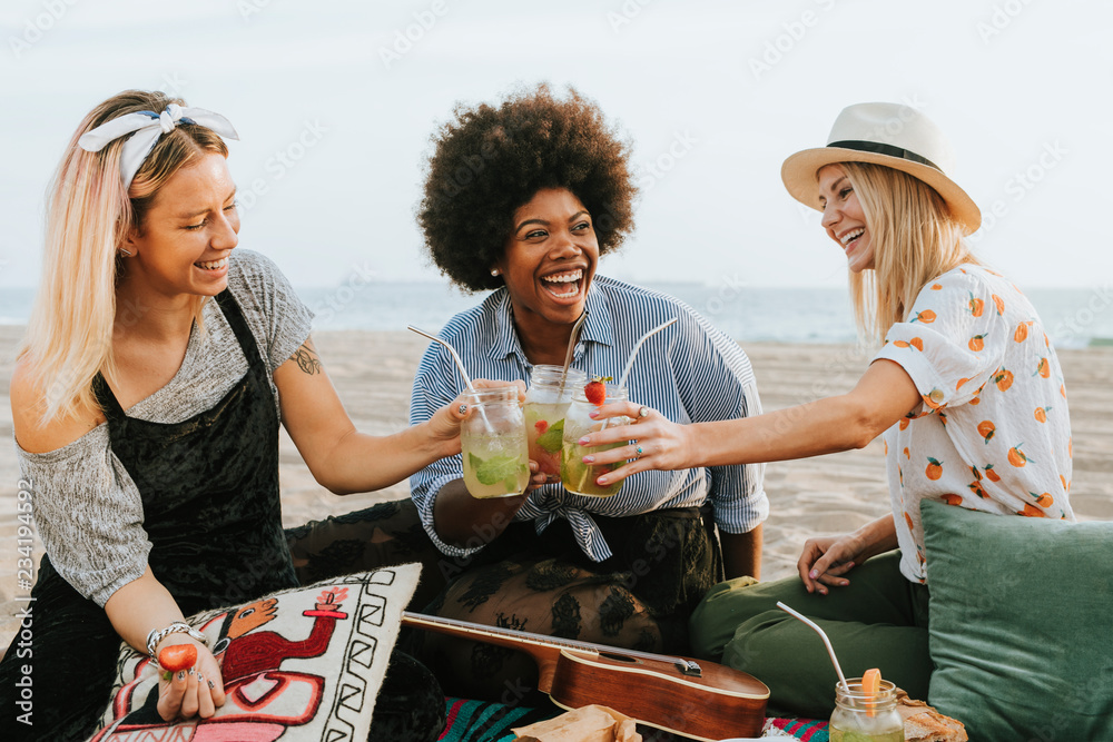 Friends clinking their glasses at a beach party