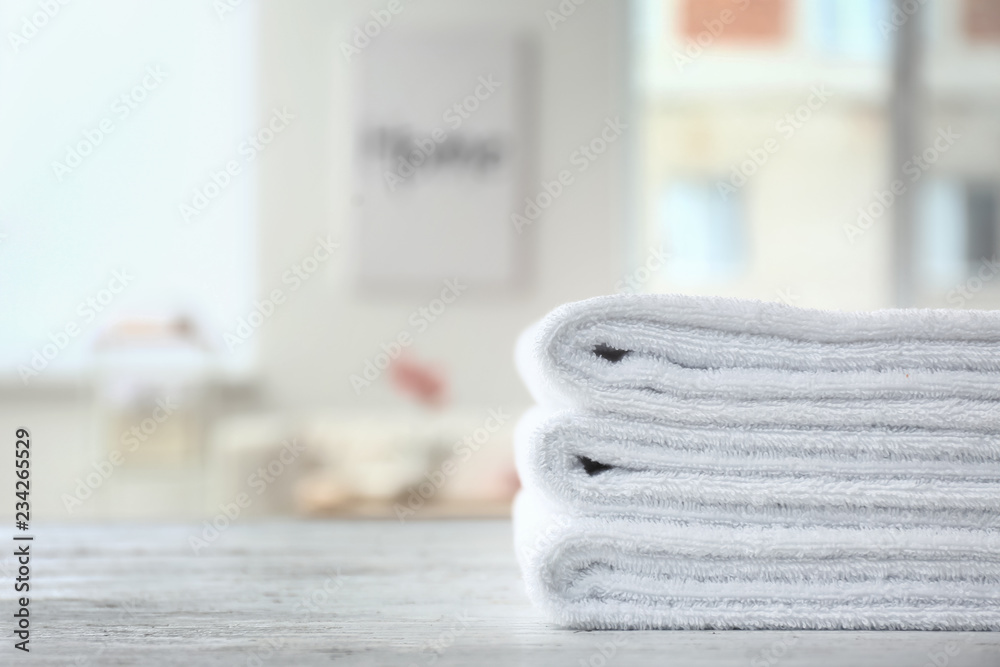 Folded white towels on light table indoors