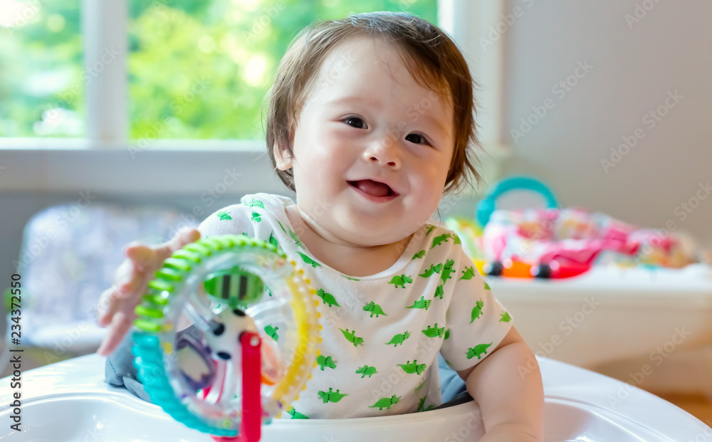 Happy little baby boy playing with his toys