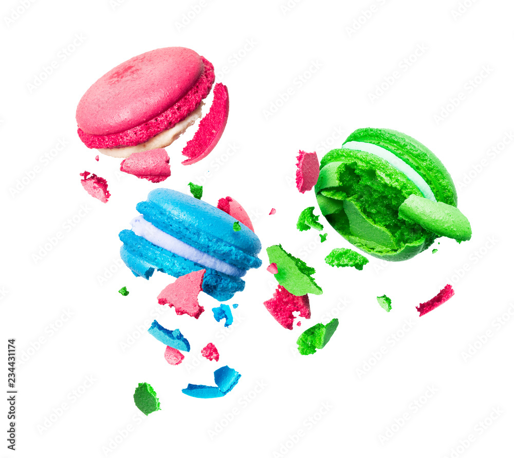 Colorful macaroons are torn to pieces in the air on a white background