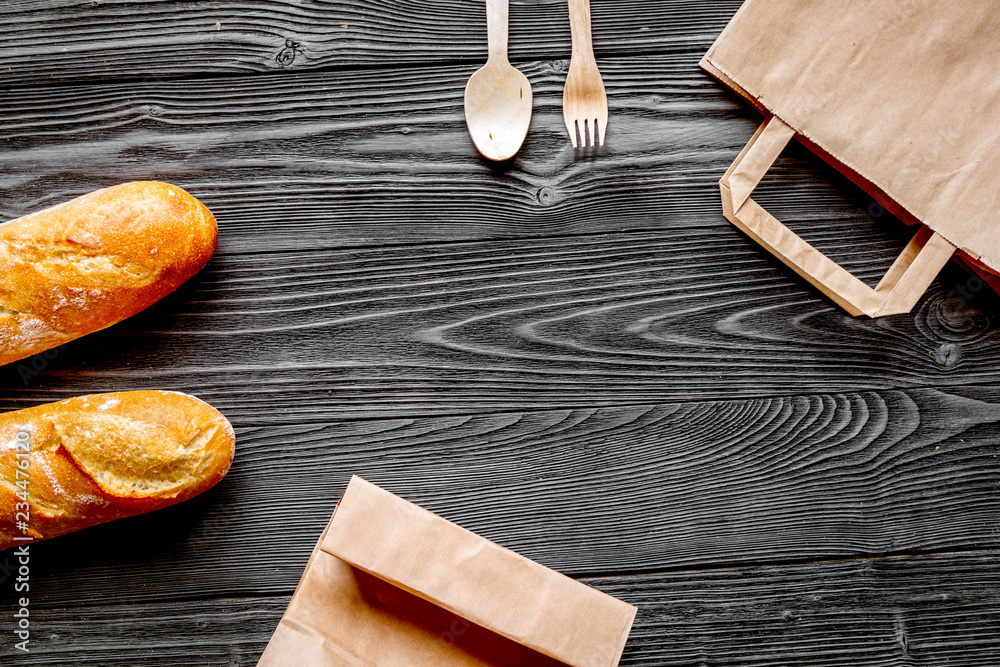 bread in paper bag on wooden background