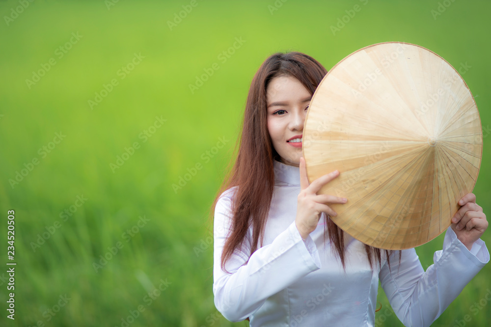 身穿越南敖岱传统服饰、面带微笑的越南女孩画像。