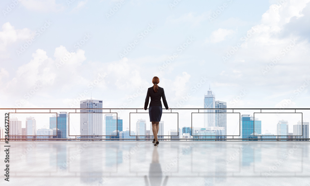 Sunrise above skyscrapers and businesswoman facing new day