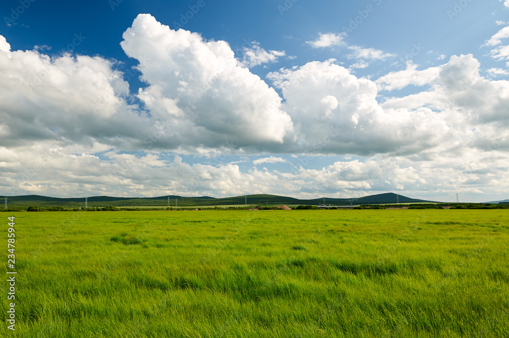 The beautiful cloudscape and rainbow on the grassland.