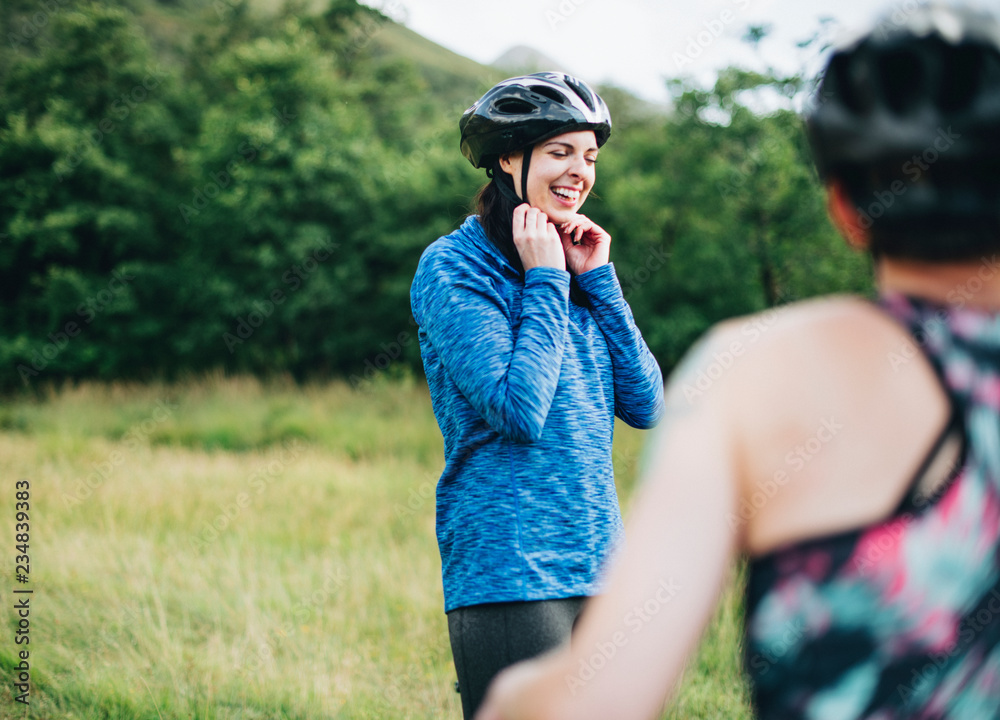 Cyclist putting on her bike helmet