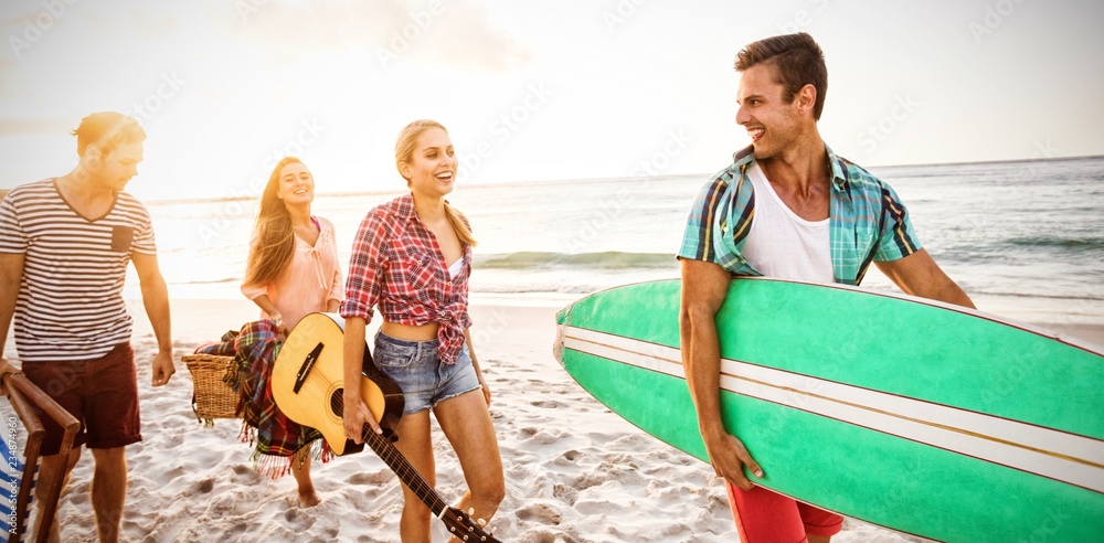 Friends carrying a surfboard and basket