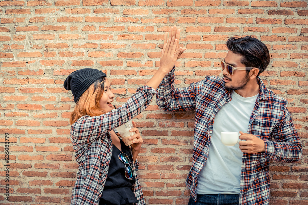 Happy young man and woman drink coffee on street.