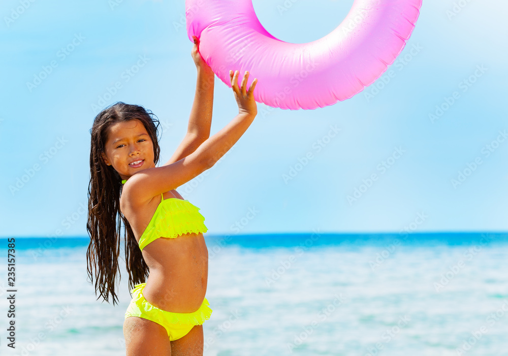 Asian girl with swim tube playing on the beach