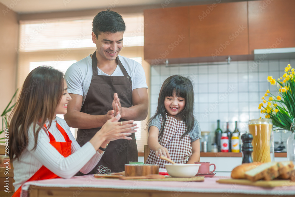 女儿和父母正在准备烘焙家庭概念。