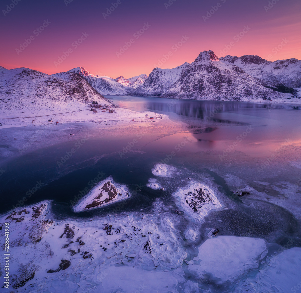 雪山鸟瞰图，蓝色的大海和霜冻的海岸，水中的倒影和co的紫色天空