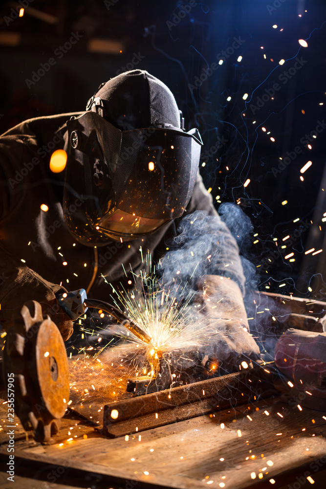 Welder working in workshop factory